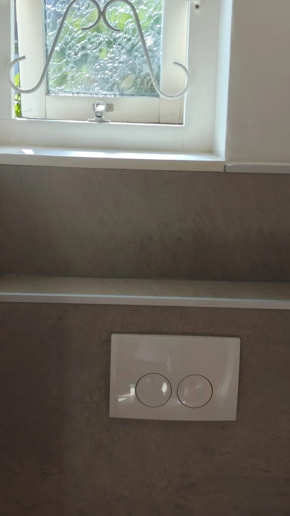 Witte drukplaat op een grijze betonlook voorzetwand
