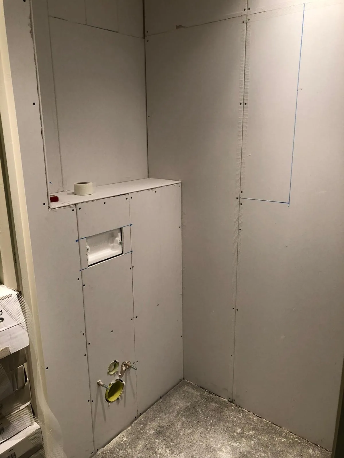 Nieuwe voorzetwand met plank, opening voor de drukplaat en aansluitingen voor het hangtoilet