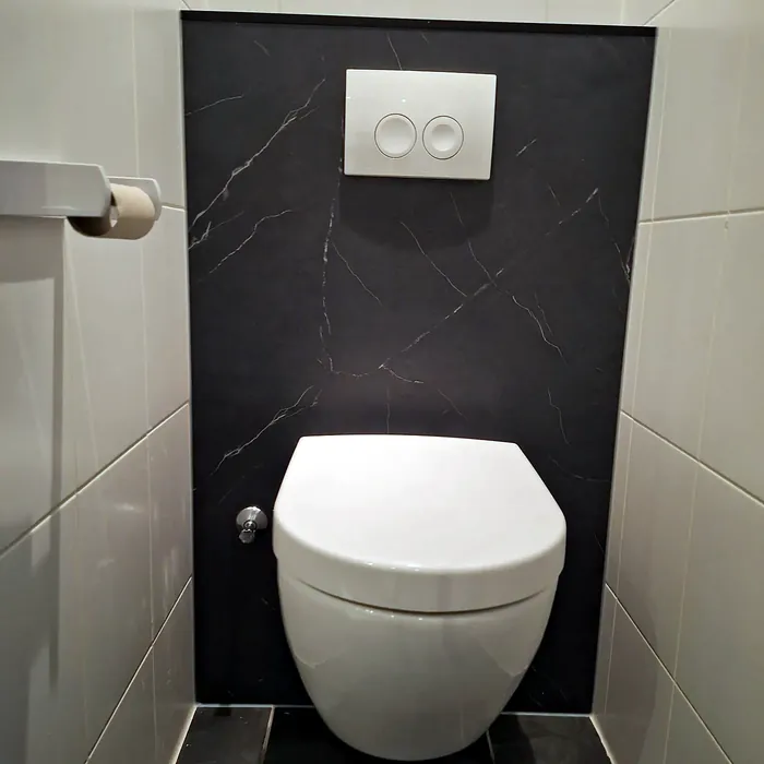 Hangtoilet met donkere marmerlook voorzetwand en wit bedieningspaneel
