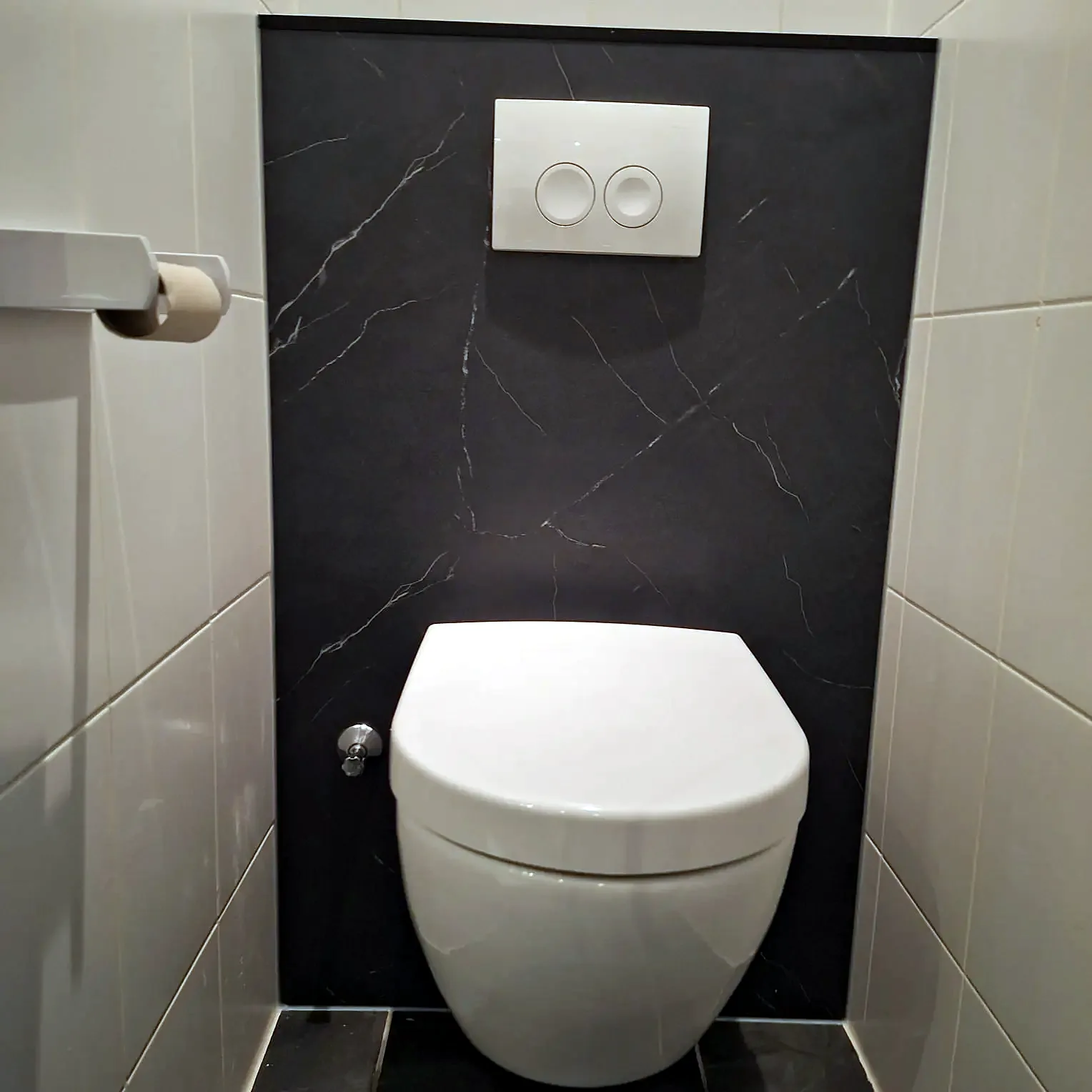 Hangtoilet met donkere marmerlook voorzetwand en wit bedieningspaneel