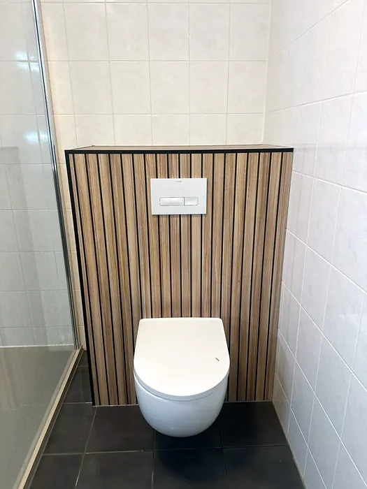 Hangtoilet tegen een voorzetwand met houten lamellen