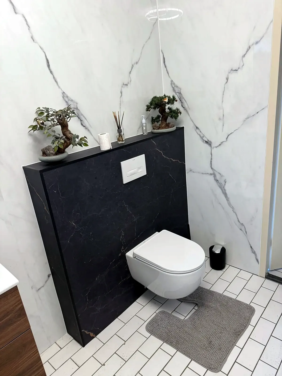 Zwevend toilet met zwarte marmerlook voorzetwand